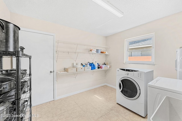 laundry area with baseboards, a textured ceiling, laundry area, and separate washer and dryer