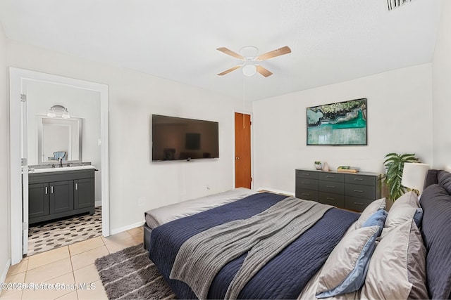 bedroom featuring baseboards, ceiling fan, ensuite bathroom, and light tile patterned floors