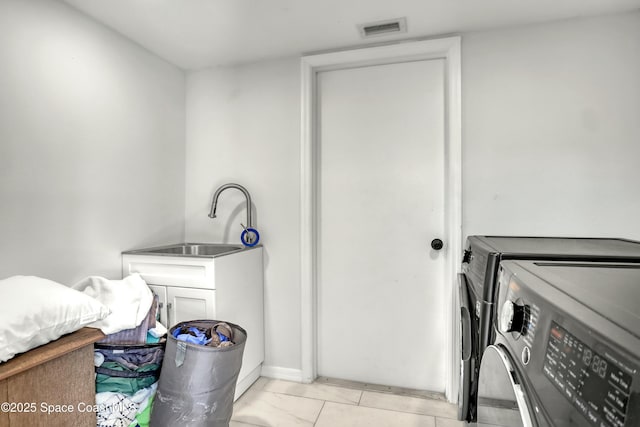 washroom featuring a sink, visible vents, cabinet space, and washing machine and clothes dryer