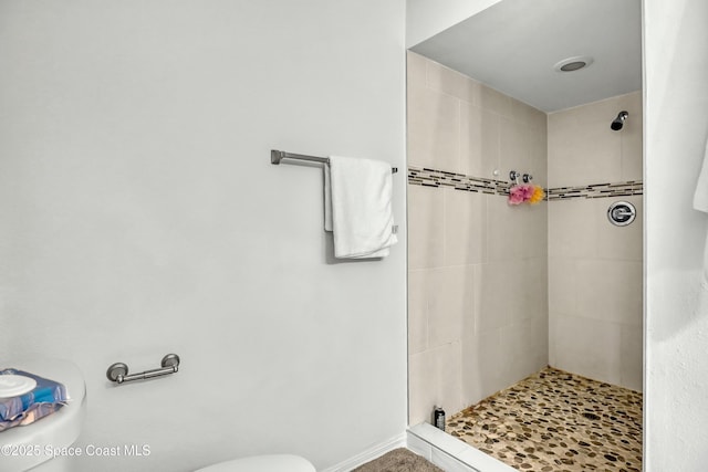 full bath featuring toilet and tiled shower