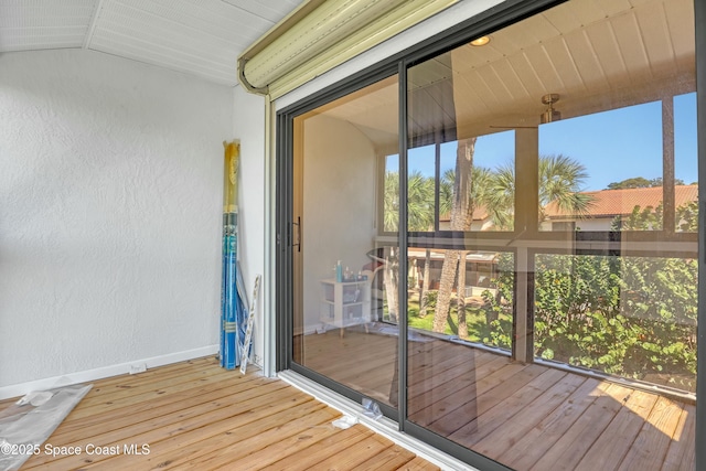 unfurnished sunroom featuring vaulted ceiling