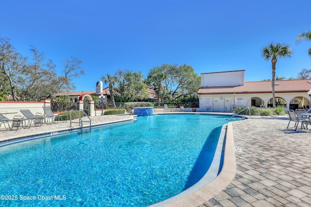 pool with a patio and fence