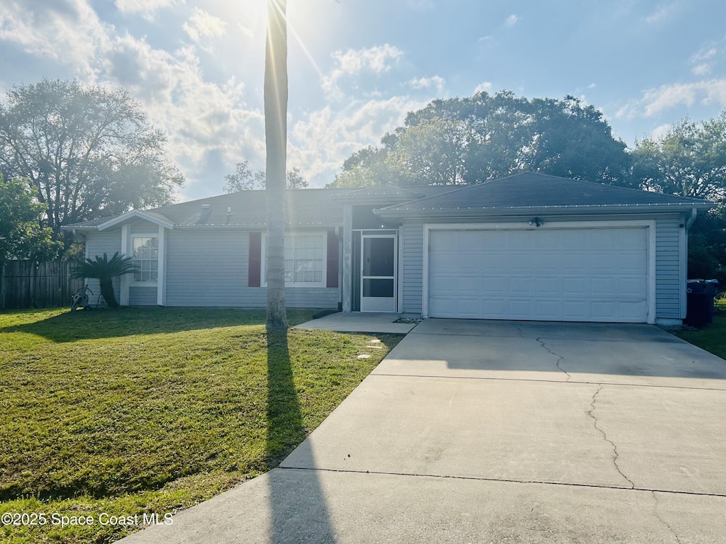 single story home with a front yard, driveway, an attached garage, and fence