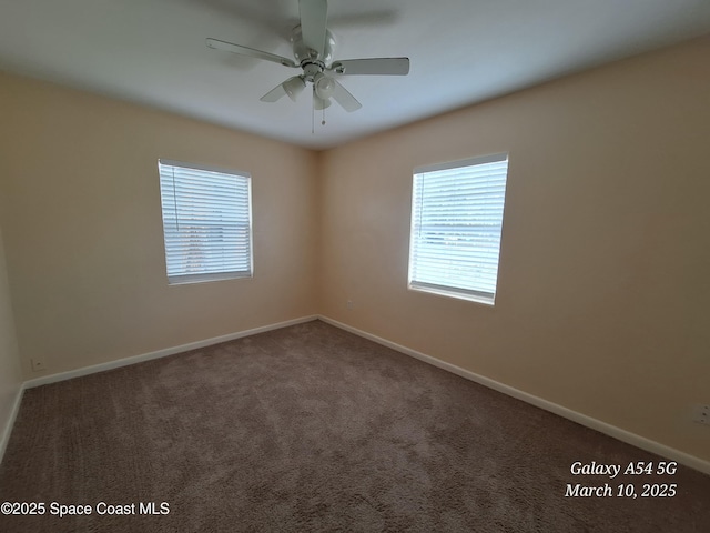 carpeted empty room with a ceiling fan and baseboards