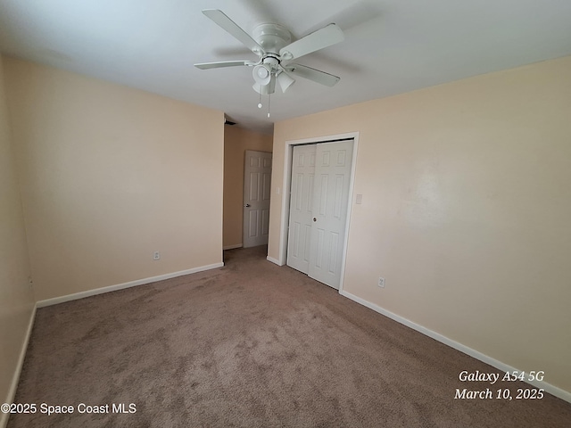 unfurnished bedroom with a closet, baseboards, a ceiling fan, and carpet flooring