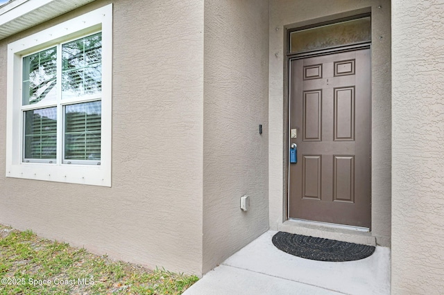 entrance to property featuring stucco siding