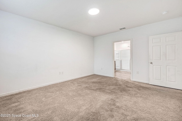 carpeted spare room with visible vents and baseboards