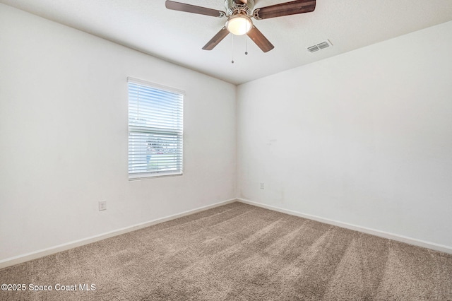 spare room with visible vents, ceiling fan, baseboards, and carpet