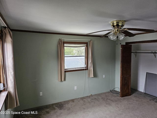 unfurnished bedroom featuring a ceiling fan, carpet, and a closet