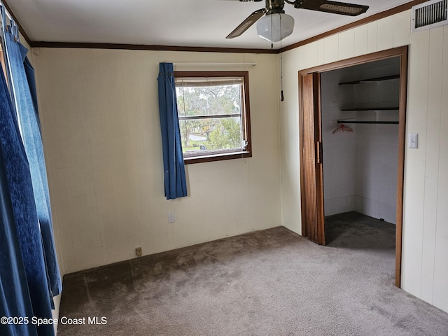 unfurnished bedroom featuring ornamental molding, carpet, a closet, and visible vents