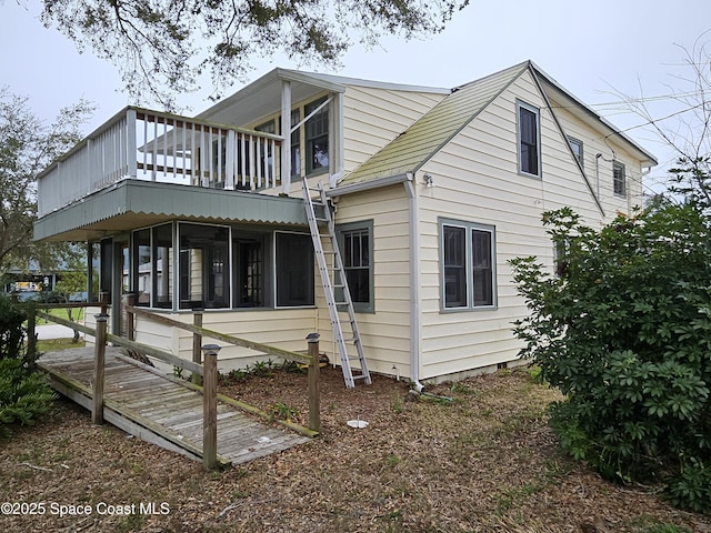 view of property exterior with a sunroom and a deck