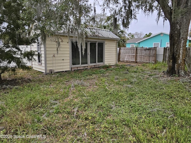 rear view of property with an outbuilding and a fenced backyard