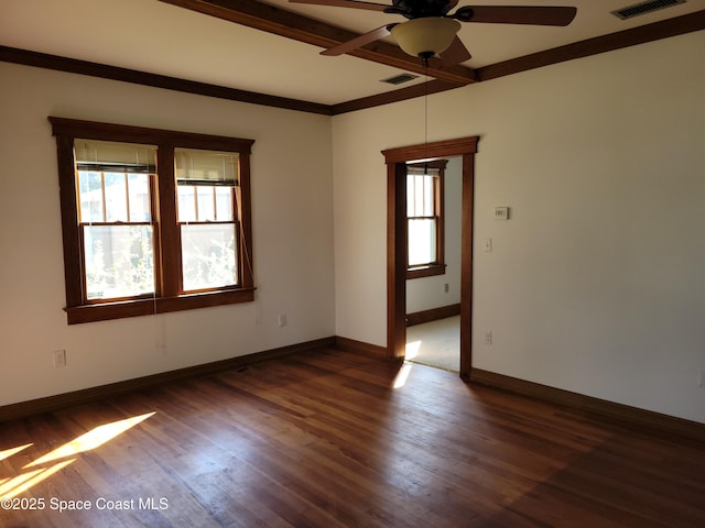 empty room featuring visible vents, dark wood-type flooring, ornamental molding, ceiling fan, and baseboards