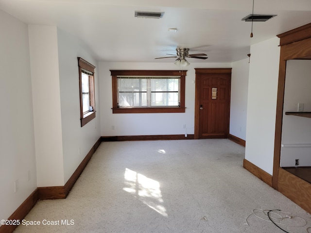 unfurnished room featuring visible vents, ceiling fan, and baseboards