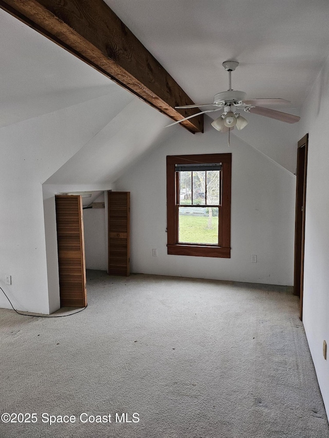 additional living space with lofted ceiling with beams, ceiling fan, and carpet flooring