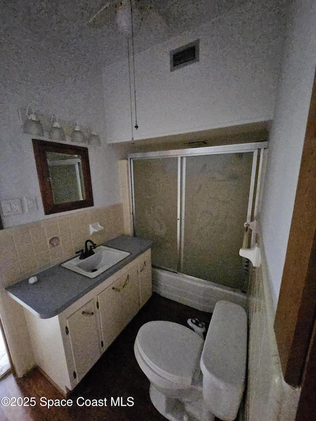 bathroom with visible vents, backsplash, toilet, a shower stall, and vanity