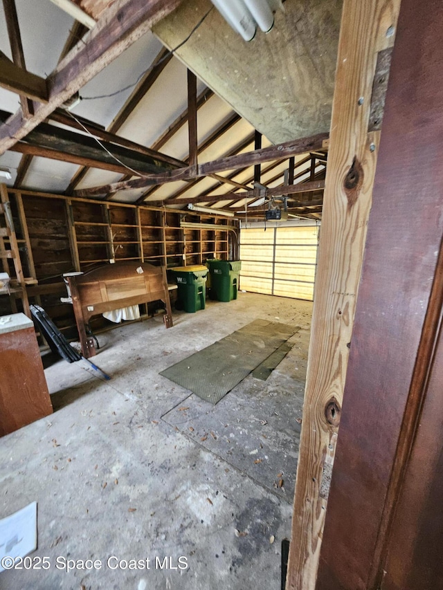 miscellaneous room with a garage and vaulted ceiling