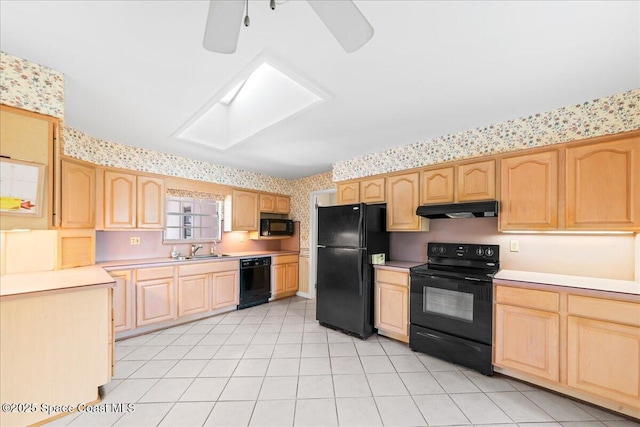 kitchen featuring light brown cabinets, wallpapered walls, black appliances, light countertops, and under cabinet range hood