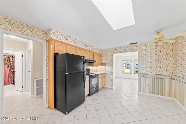 kitchen with light brown cabinets, wallpapered walls, ceiling fan, under cabinet range hood, and black appliances