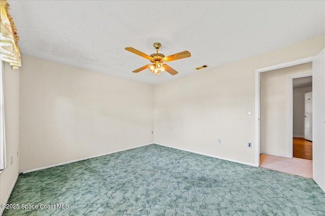 spare room with visible vents, a ceiling fan, a textured ceiling, carpet floors, and baseboards