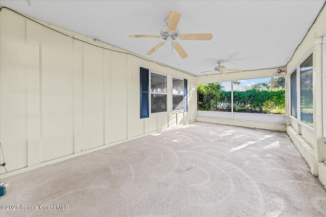 unfurnished sunroom with ceiling fan