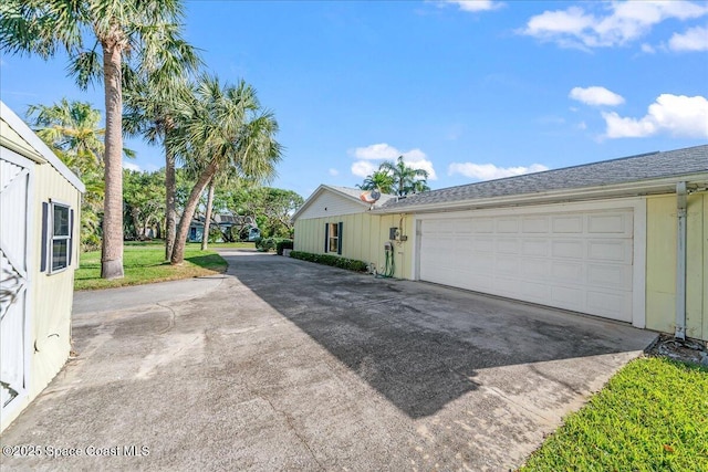 view of home's exterior featuring a yard, a garage, and driveway