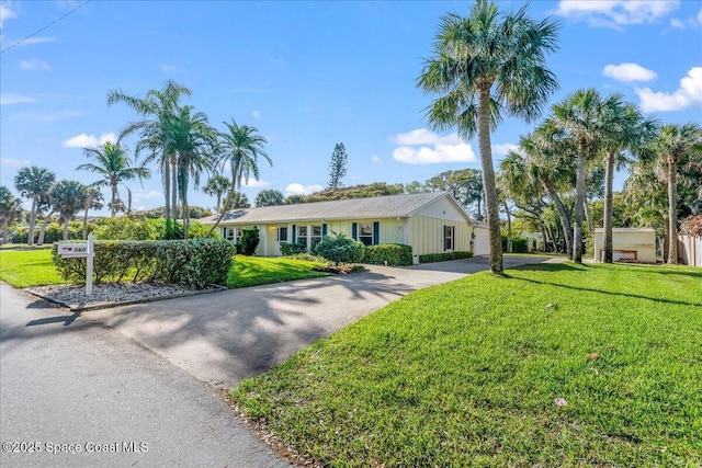 single story home featuring driveway and a front lawn