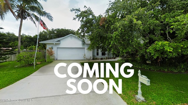 view of front of property with concrete driveway, an attached garage, and a front lawn