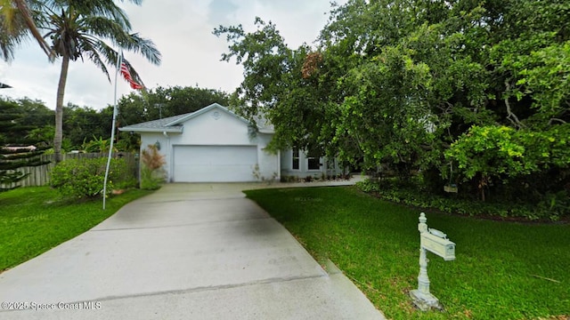 view of front of house with stucco siding, an attached garage, concrete driveway, and a front lawn