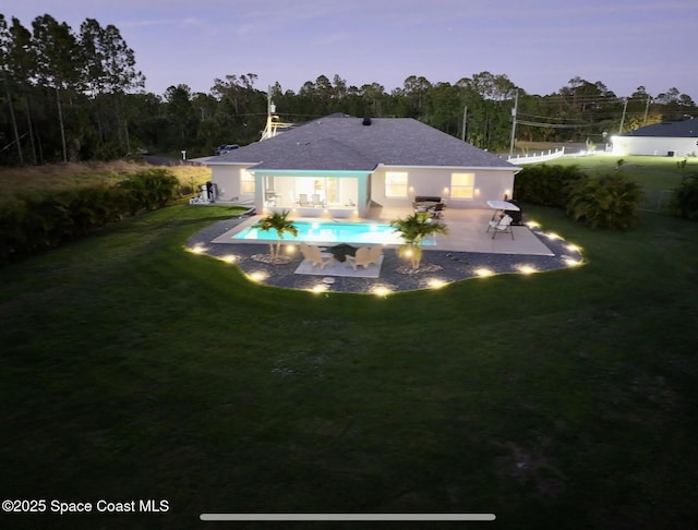 rear view of house featuring an outdoor pool, a lawn, and a patio area