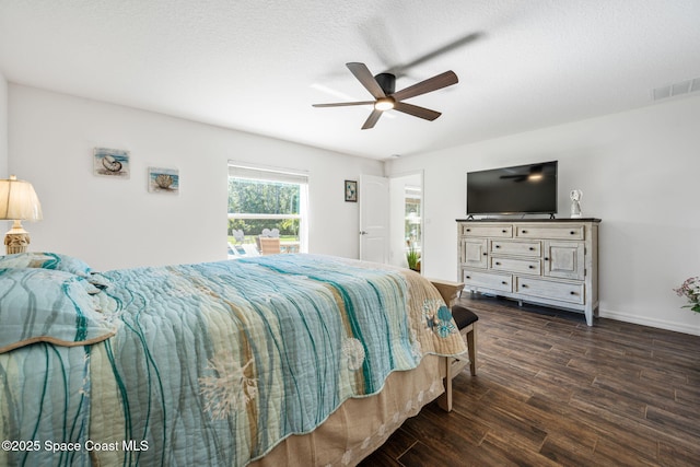 bedroom with a ceiling fan, visible vents, baseboards, dark wood-style flooring, and a textured ceiling