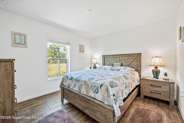 bedroom featuring baseboards and wood finish floors