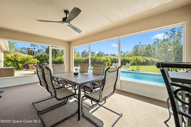 sunroom / solarium featuring plenty of natural light and a ceiling fan