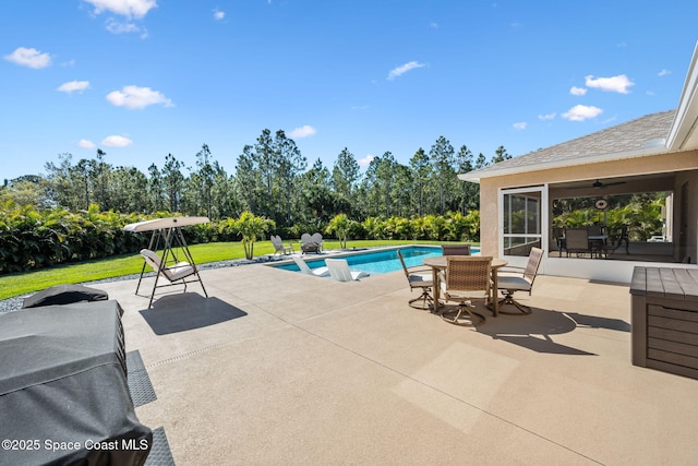 pool with outdoor dining area, a patio, and a yard