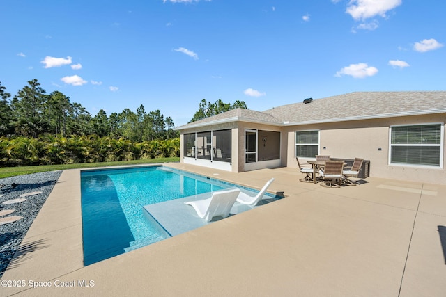 outdoor pool featuring outdoor dining space, a patio, and a sunroom