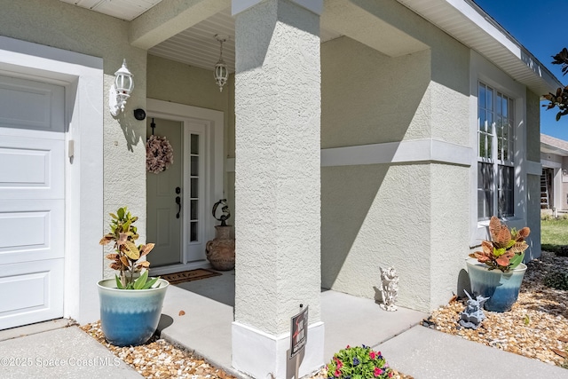 doorway to property featuring a garage and stucco siding