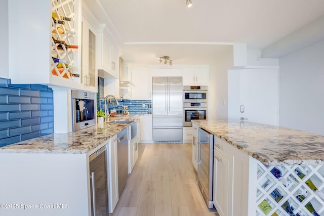 kitchen with white cabinets, beverage cooler, light wood-style floors, and appliances with stainless steel finishes