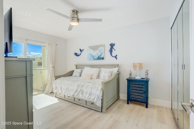 bedroom featuring a closet, baseboards, light wood-style floors, and ceiling fan