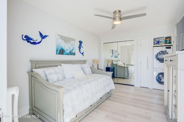 bedroom with a ceiling fan, light wood-style floors, and stacked washer / drying machine