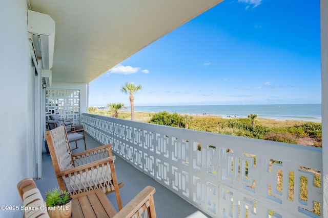 balcony featuring a view of the beach and a water view