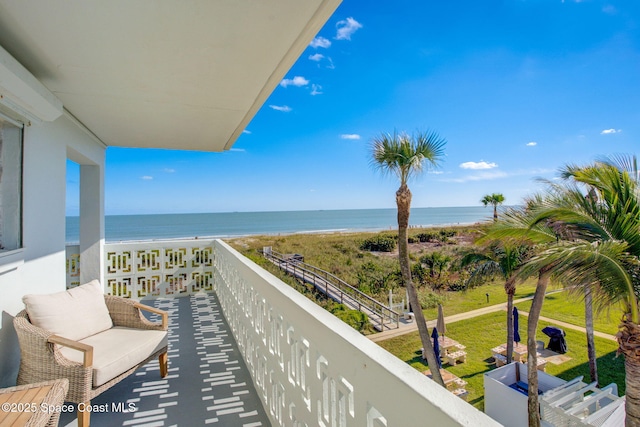 balcony featuring a beach view and a water view