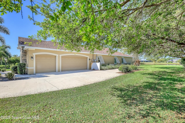 view of front of house featuring a front yard, an attached garage, concrete driveway, and stucco siding