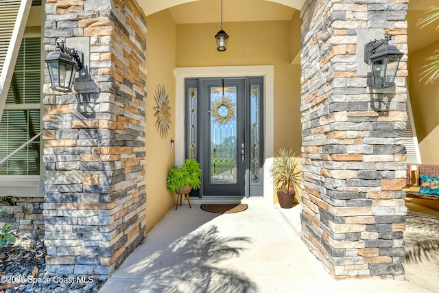 entrance to property with stone siding and stucco siding