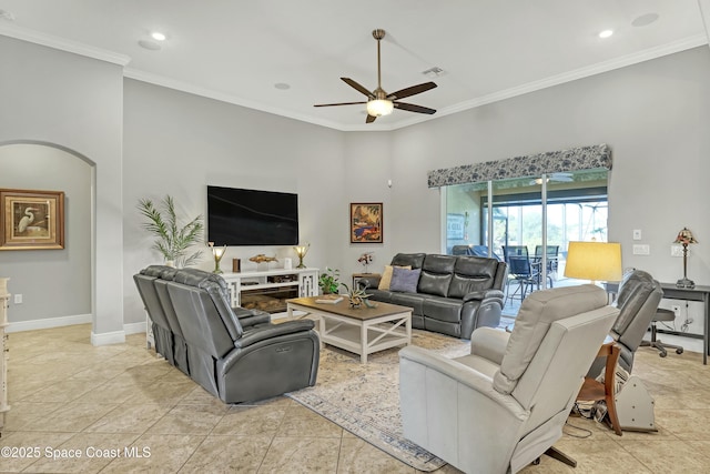 living area featuring visible vents, ceiling fan, baseboards, ornamental molding, and arched walkways