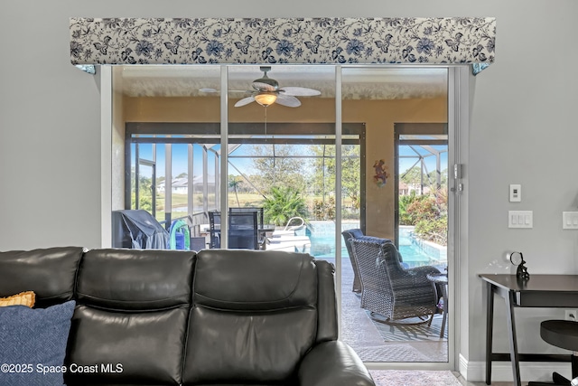 living room featuring ceiling fan and a sunroom