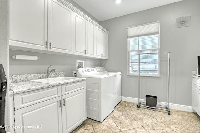 clothes washing area featuring baseboards, light tile patterned floors, washer and dryer, cabinet space, and a sink