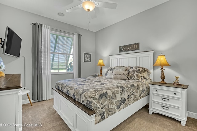 bedroom featuring baseboards, light colored carpet, and a ceiling fan