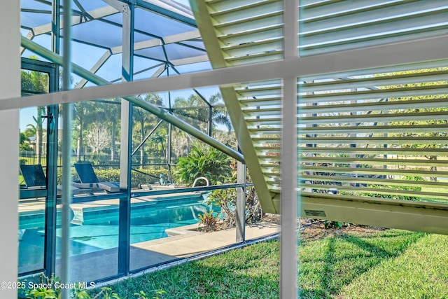 outdoor pool featuring glass enclosure and a patio area