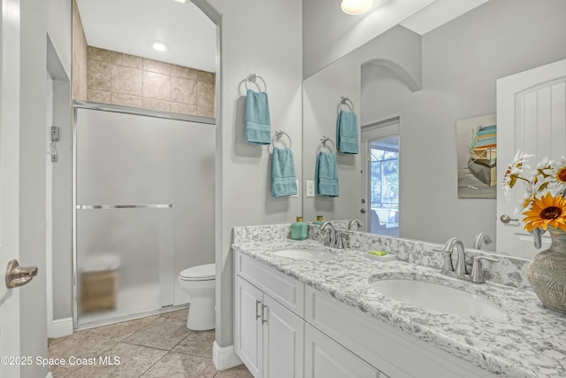 full bathroom with tile patterned flooring, toilet, a stall shower, and a sink