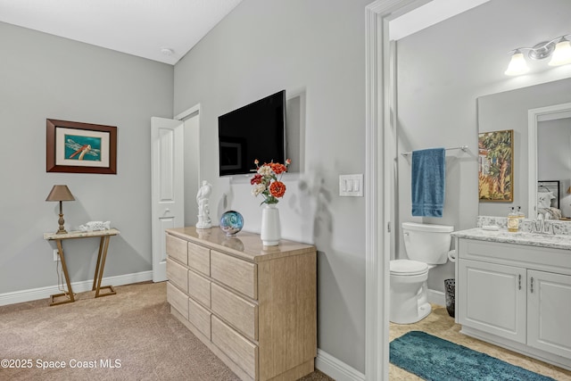 bathroom with vanity, toilet, and baseboards